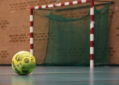 in der Halle liegt ein gelber Ball auf dem Boden vor dem Tor und ist ein Symbolbild für Handball in der Halle liegt ein gelber Ball auf dem Boden vor dem Tor und ist ein Symbolbild für Handball