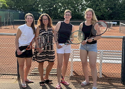 vier Tennisspielerinnen stehen nach dem Sieg fürbass Foto mit ihren Schlägern in der Hand vor dem Tennisplatz vier Tennisspielerinnen stehen nach dem Sieg fürbass Foto mit ihren Schlägern in der Hand vor dem Tennisplatz